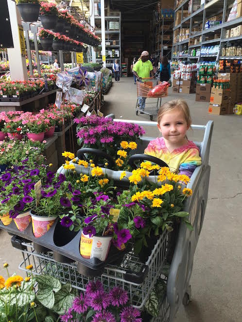 little girl sitting with flowers